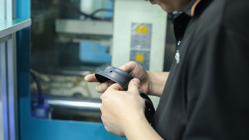 Engineer inspecting the injection-molded earcup for quality verification