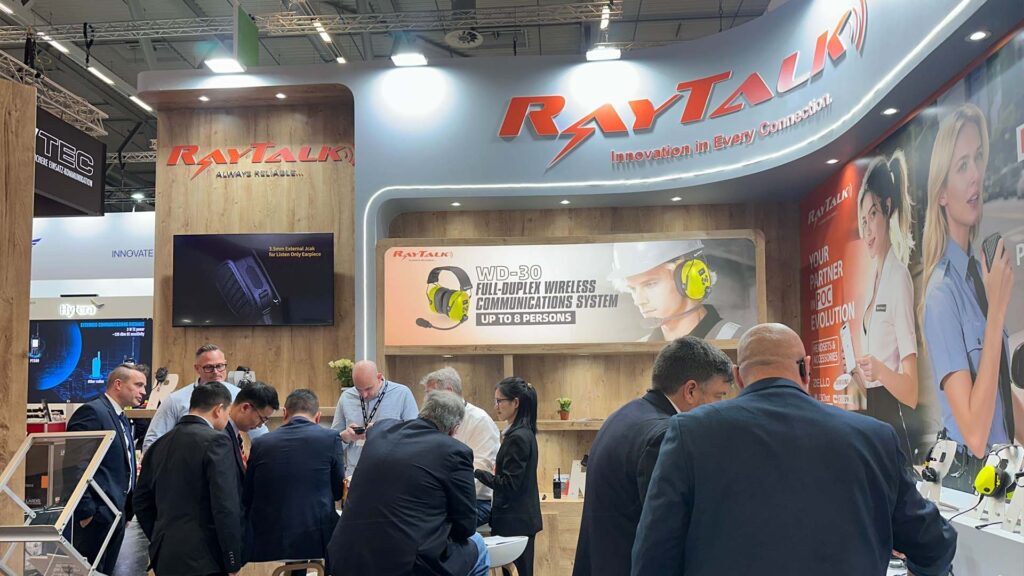 Many visitors at the RayTalk booth trying out radio communication products.