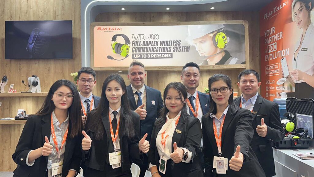 The RayTalk team smiling together in a group photo at the booth.