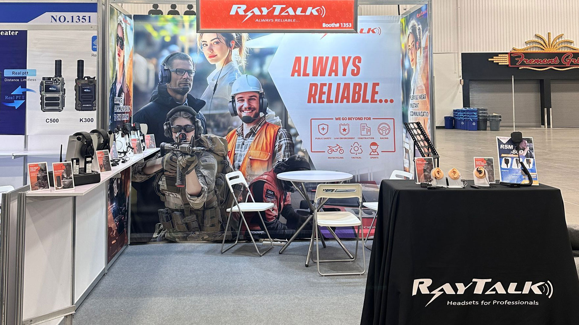 Booth at IWCE 2025 showcasing headsets, earpieces, and speaker microphones for radio communication