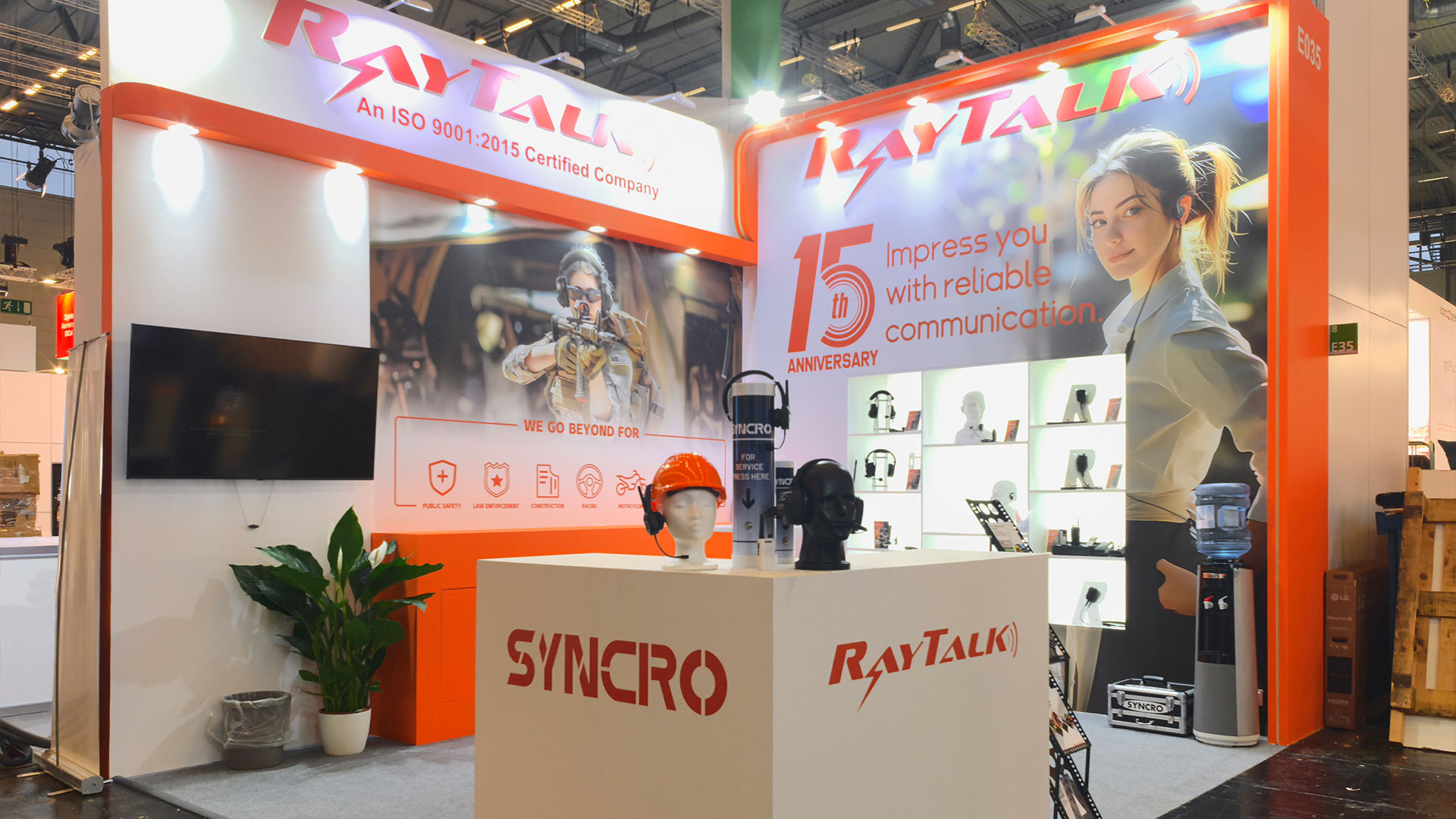 RayTalk booth at PMRExpo 2024 showcasing two-way radio earpieces, headsets, and speaker mics for clear communication
